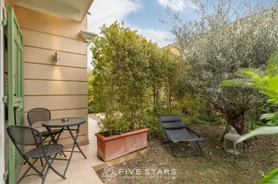 a patio with a table and chairs and trees at Villa Artemys - Five Stars Holiday House in Saint-Jean-Cap-Ferrat