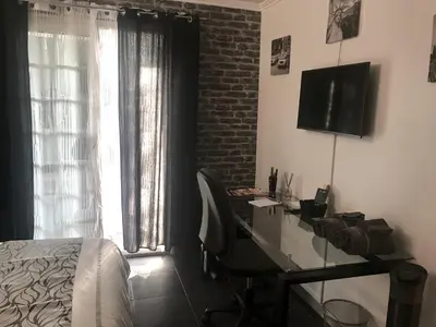a bedroom with a desk and a bed and a television at Chambres chez l'habitant Villa l'Île aux Anges in Saint-Andre-de-la-Roche