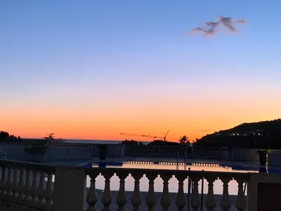 a bird flying in the sky at sunset at Appartement agréable en bord de mer in Villefranche-sur-Mer