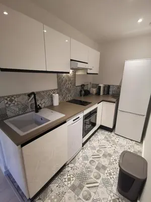 a kitchen with white cabinets and a tile floor at Appartement Vieux-Nice N in Nice