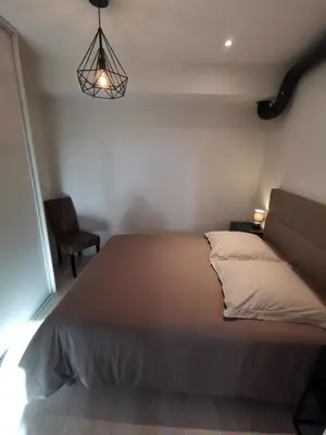 a bed in a bedroom with a lamp and a chair at Appartement Vieux Nice S in Nice