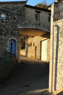 an entrance to a stone building with a garage at Rez de villa avec beau jardin et belle vue in Saint-Laurent-du-Var