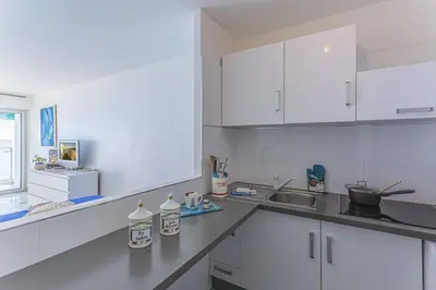 a white kitchen with white cabinets and a sink at MY CASA - PROM 199 - Spacious studio - Promenade - Sea View in Nice