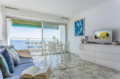 a living room with a couch and a television and a table at MY CASA - PROM 199 - Spacious studio - Promenade - Sea View in Nice