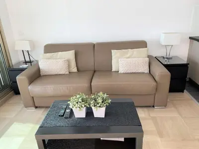 a living room with a couch and a coffee table at SEA FRONT - panoramic sea view studio with terrace in Nice