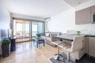 a kitchen and living room with a couch and a table at SEA FRONT - panoramic sea view studio with terrace in Nice