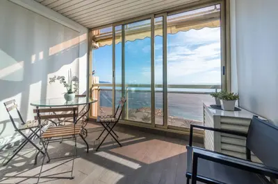 a balcony with a table and chairs and a view of the ocean at SEA FRONT - panoramic sea view studio with terrace in Nice