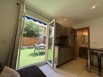 a kitchen with a sliding glass door leading to a garden at CONGRES - Appartement 4 personnes grande terrasse dans le Carré d'Or à Nice in Nice