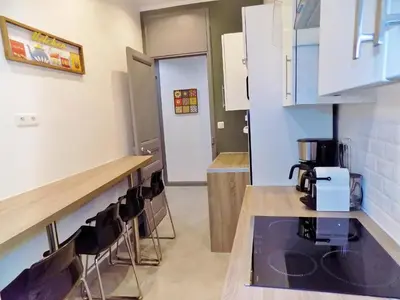 a kitchen with a counter and chairs in a room at GARE 5 minutes GARIBALDI RÉPUBLIQUE chambre PRIVEE non FUMEUR pour voyageurs CALMES TRAM au pied de l'immeuble in Nice