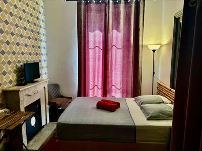 a bedroom with a bed with a pink curtain at GARE 5 minutes GARIBALDI RÉPUBLIQUE chambre PRIVEE non FUMEUR pour voyageurs CALMES TRAM au pied de l'immeuble in Nice
