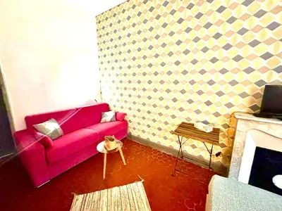 a living room with a pink couch and a fireplace at GARE 5 minutes GARIBALDI RÉPUBLIQUE chambre PRIVEE non FUMEUR pour voyageurs CALMES TRAM au pied de l'immeuble in Nice