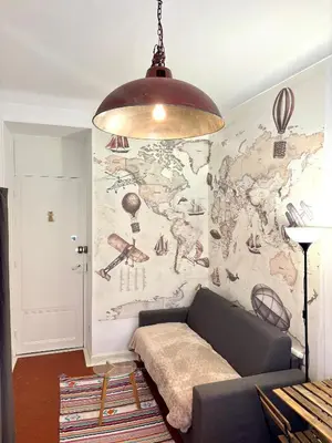 a living room with a couch and a map of the world at GARE 5 minutes GARIBALDI RÉPUBLIQUE chambre PRIVEE non FUMEUR pour voyageurs CALMES TRAM au pied de l'immeuble in Nice