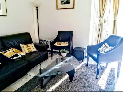 a living room with a black couch and two chairs at Le Palladium quartier Tzaréwitch Nice in Nice
