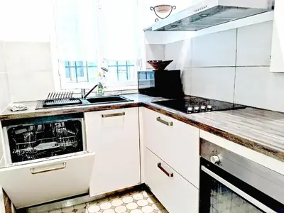 a kitchen with white cabinets and a stove top oven at Le Palladium quartier Tzaréwitch Nice in Nice