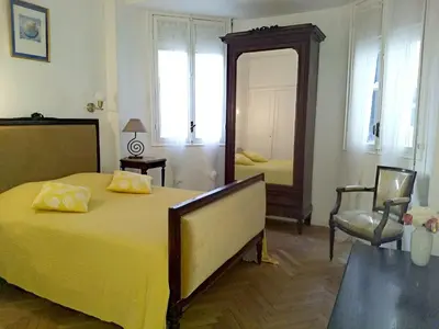 a bedroom with a large yellow bed and a mirror at Le Palladium quartier Tzaréwitch Nice in Nice