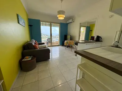 a living room with a couch and a kitchen at NEREIDES - Appartement 4 personnes avec Vue Mer exceptionnelle à Villefranche-sur-Mer in Villefranche-sur-Mer