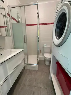 a bathroom with a shower toilet and a washing machine at NEREIDES - Appartement 4 personnes avec Vue Mer exceptionnelle à Villefranche-sur-Mer in Villefranche-sur-Mer
