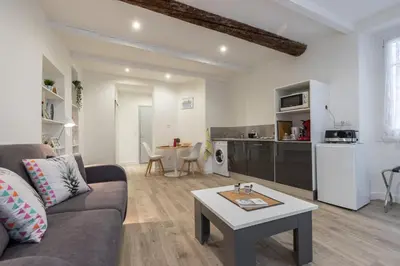 a living room with a couch and a table at Cosy Studio in the Old Town - St François Square in Nice