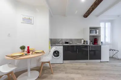 a kitchen with a washing machine and a table at Cosy Studio in the Old Town - St François Square in Nice