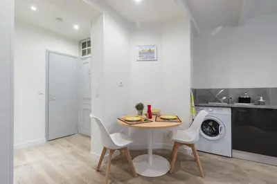 a small kitchen with a table and chairs and a washing machine at Cosy Studio in the Old Town - St François Square in Nice