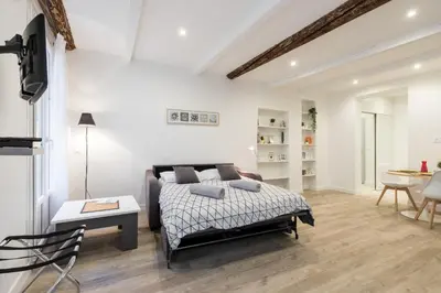 a bedroom with a bed and a living room at Cosy Studio in the Old Town - St François Square in Nice
