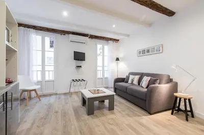 a living room with a couch and a table at Cosy Studio in the Old Town - St François Square in Nice