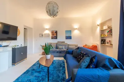 a living room with a blue couch and a tv at The Big Flat - Hypercentre - Car park - Virtual tour in Nice