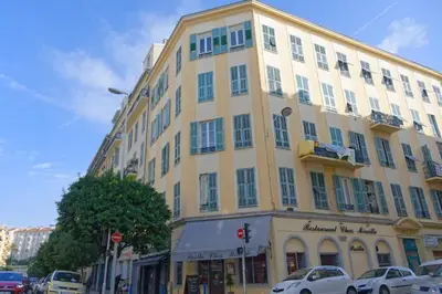 a large yellow building with cars parked in front of it at The Big Flat - Hypercentre - Car park - Virtual tour in Nice