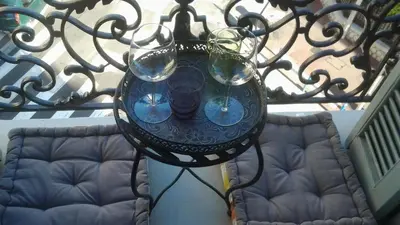 a wrought iron table with wine glasses on a balcony at Nizza - Boutique Wohnung - near Hotel Negresco in Nice