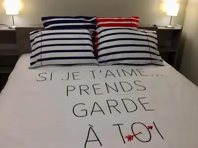 a bed with two pillows and a sign on it at PALAIS ELISABETH PROMENADE DES ANGLAIS in Nice
