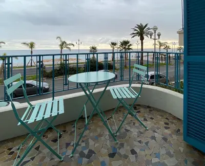 a table and two chairs on a balcony with the ocean at PALAIS ELISABETH PROMENADE DES ANGLAIS in Nice
