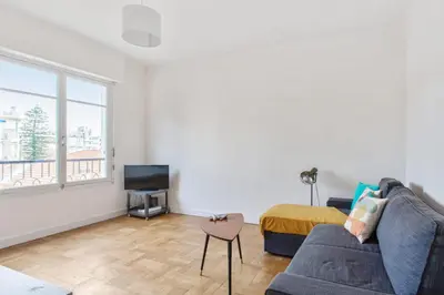 a living room with a couch and a tv at Appartement Libération - Welkeys in Nice