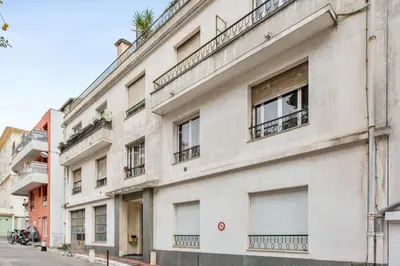 a white building with balconies on a street at Appartement Libération - Welkeys in Nice