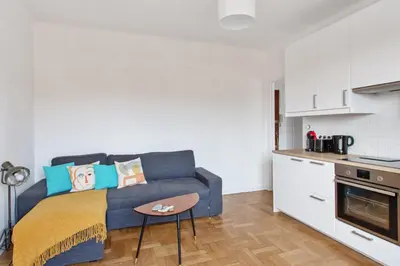 a living room with a couch and a kitchen at Appartement Libération - Welkeys in Nice
