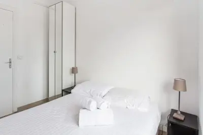 a white bedroom with two towels on a bed at Appartement Libération - Welkeys in Nice