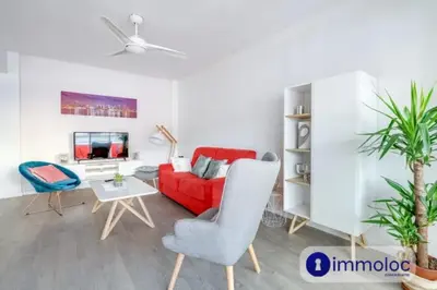 a living room with a red couch and a table at Air-conditioned apartment in the Libération district in Nice