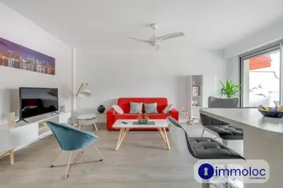 a living room with a red couch and a table at Air-conditioned apartment in the Libération district in Nice