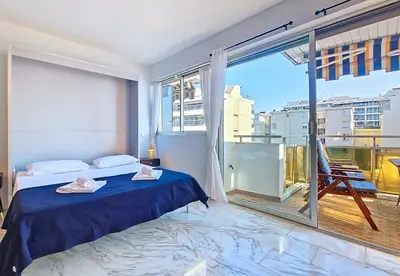 a bedroom with a bed and a large window at Nestor&Jeeves - STUDIO ROYAL LUXEMBOURG - Central - Swimming pool on roof in Nice