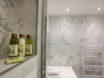a bathroom with three bottles of wine on a shelf at Nestor&Jeeves - STUDIO ROYAL LUXEMBOURG - Central - Swimming pool on roof in Nice