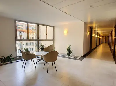 a room with a table and chairs in a building at Nestor&Jeeves - STUDIO ROYAL LUXEMBOURG - Central - Swimming pool on roof in Nice