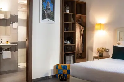 a bedroom with a bed and a bathroom with a sink at Hôtel Nice Azur Riviera in Nice