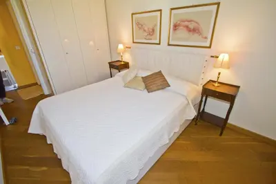 a bedroom with a large white bed with two lamps at PROMENADE HOLIDAY - GRIMALDI CITY CENTER in Nice