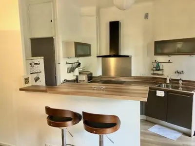 a kitchen with two bar stools and a counter top at Appartement NICE proche MER et CENTRE in Nice