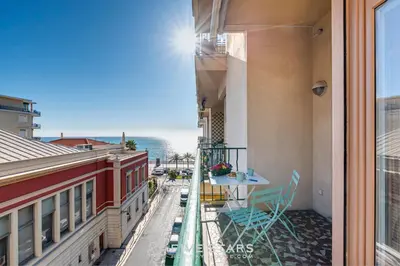 a balcony with a table and chairs and a view of the ocean at Suite Versailles Five Stars Holiday House in Nice