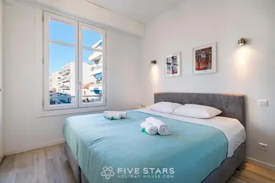 a bedroom with two towels on a bed with a window at Suite Versailles Five Stars Holiday House in Nice