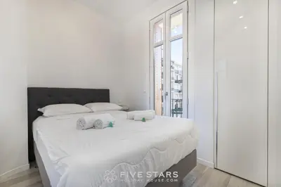 a white bedroom with a large bed with towels on it at Suite Versailles Five Stars Holiday House in Nice