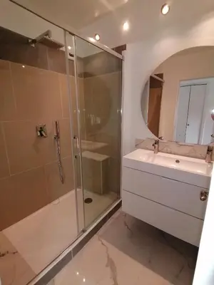 a bathroom with a glass shower and a sink at Terrasse Vue Mer Plage à 50 m Parking in Nice