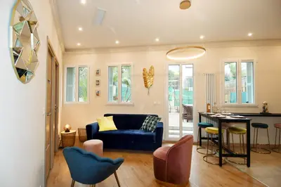 a living room with a blue couch and a table at Le jardin du port in Nice