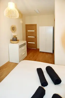 a bedroom with a white bed with two black pillows on it at Le jardin du port in Nice