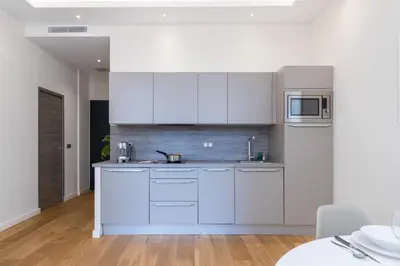 a kitchen with white cabinets and a microwave at Brand New 1 Bdr Place du Pin in Nice